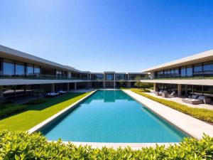 Casa luxoasă, arhitectură modernă, piscină infinită, grădini amenajate, cer senin.